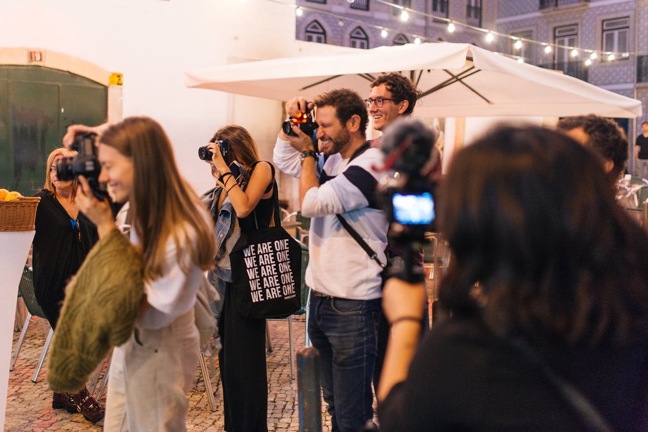 A vibrant group of photographers taking photos on a lively street in Lisbon, Portugal.